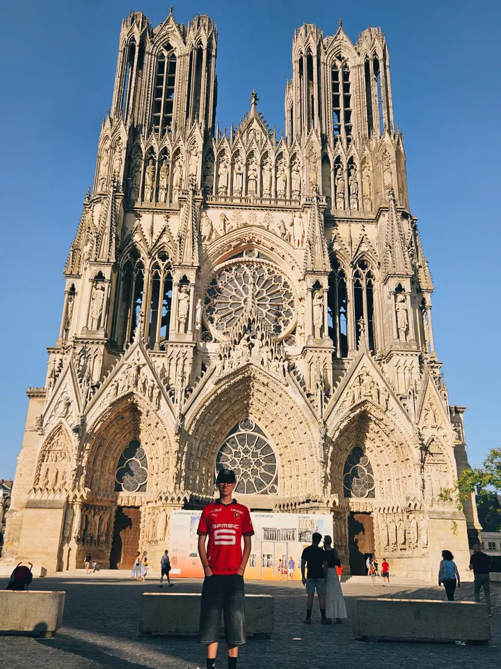Lucas devant la cathédrale de Reims
